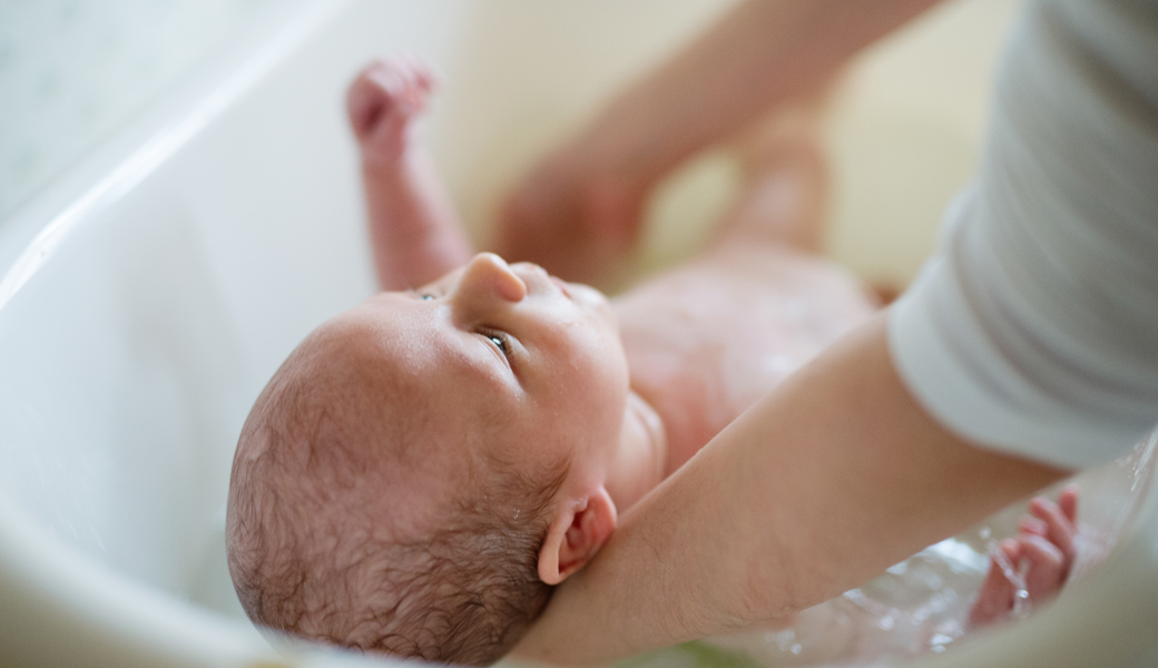 Irmgard Beerli bei ihrer Arbeit am Wochenbett: Hier badet sie gerade den zehn Tage alten Arno.