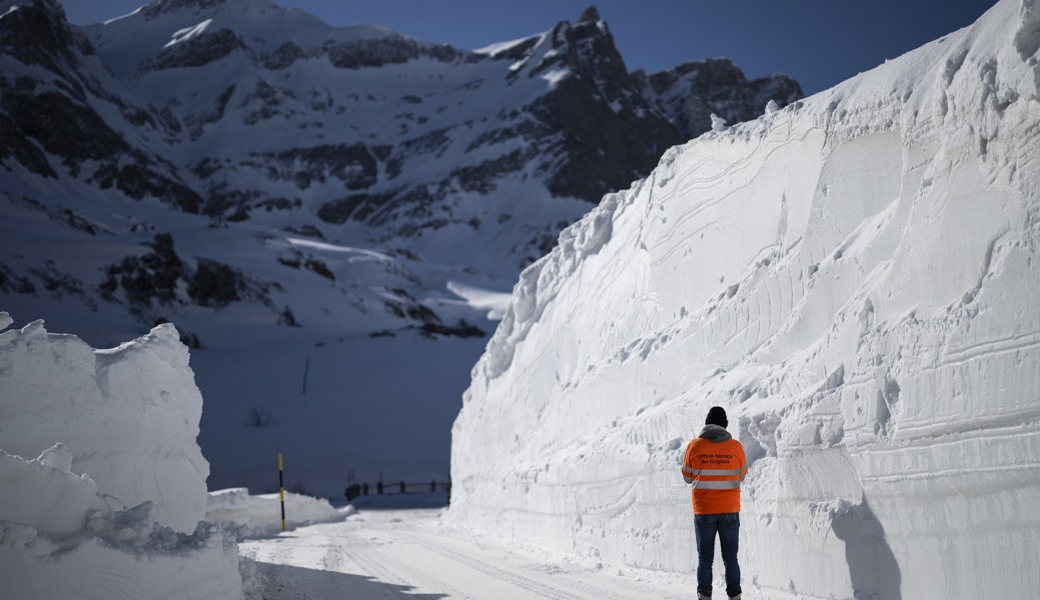 Betriebsleiter Stefanco Ciocco macht ein Foto von Schneemauern bei der Schneeraeumung am Donnerstag, 25. April 2024, am San Bernardino Pass in Splügen.