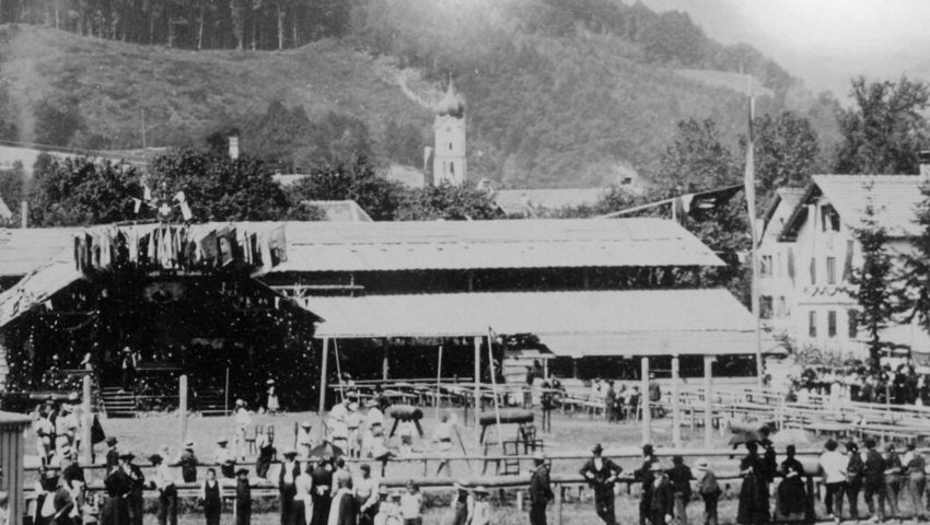  Blick auf den Turnplatz mit der grossen Festhütte, im Hintergrund ist der Turm der Kirche sichtbar.