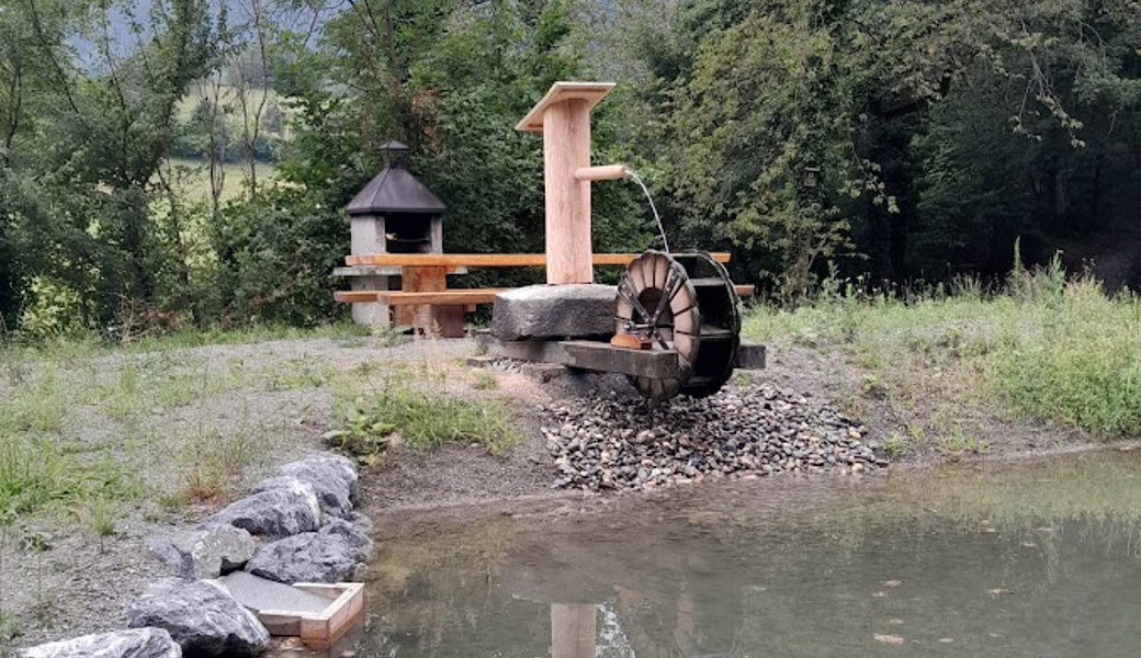 Das Wasserrad und die neue Sitzgelegenheit beim Biotop.