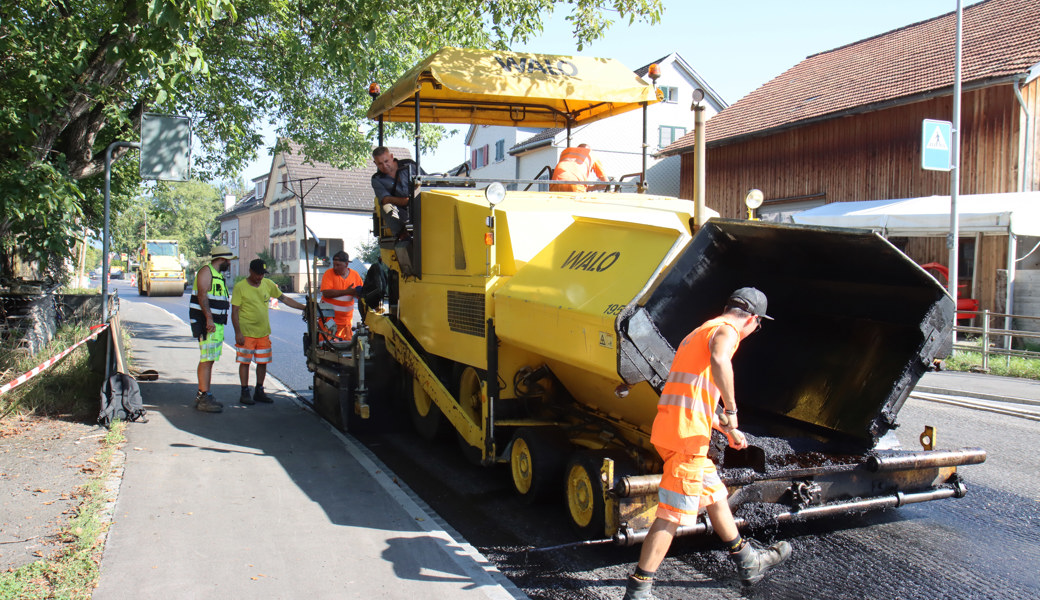 Aufwendige Strassenbelagsarbeiten bei hohen Temperaturen: Nur im Schneckentempo kann man mit dem Asphaltfertiger die Arbeiten auf der Churerstrasse in Räfis verrichten. 