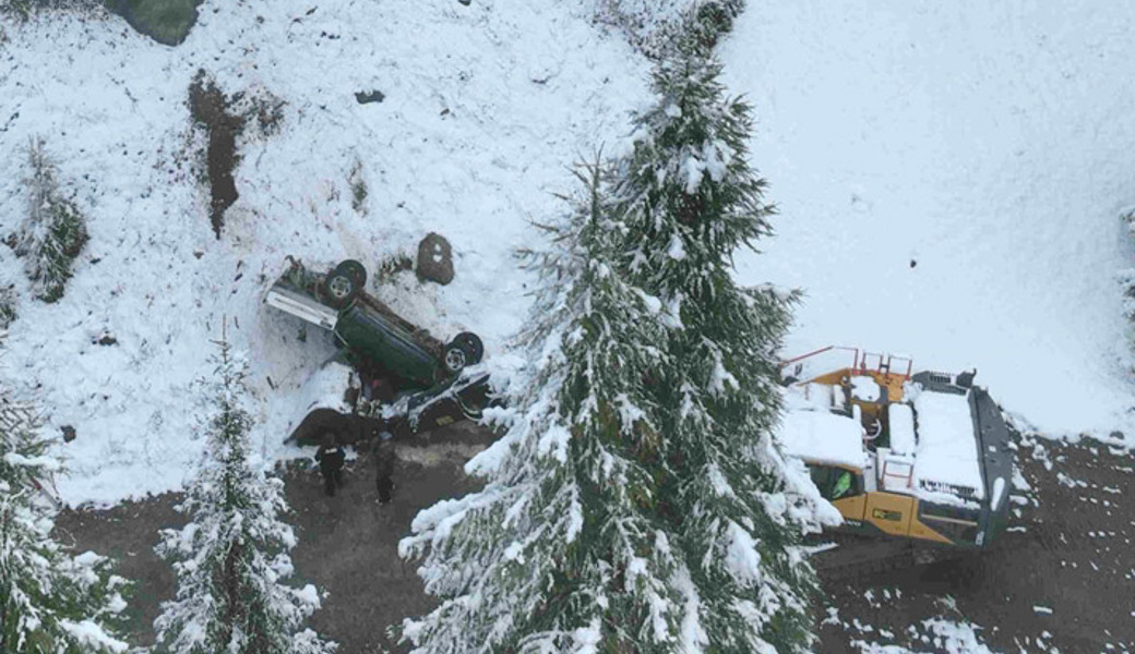 Auto rutscht auf schneebedeckter Wiese und stürzt Abhang hinunter