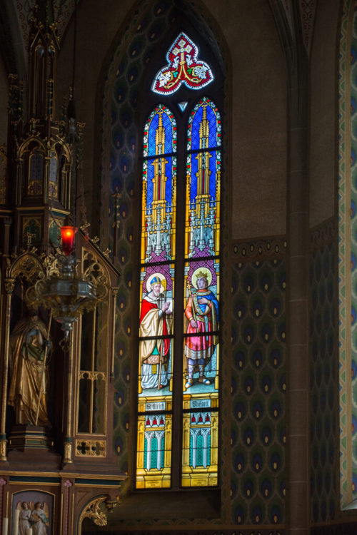  Bunte Kirchenfenster beleben den Innenraum der Kirche in Gams. 