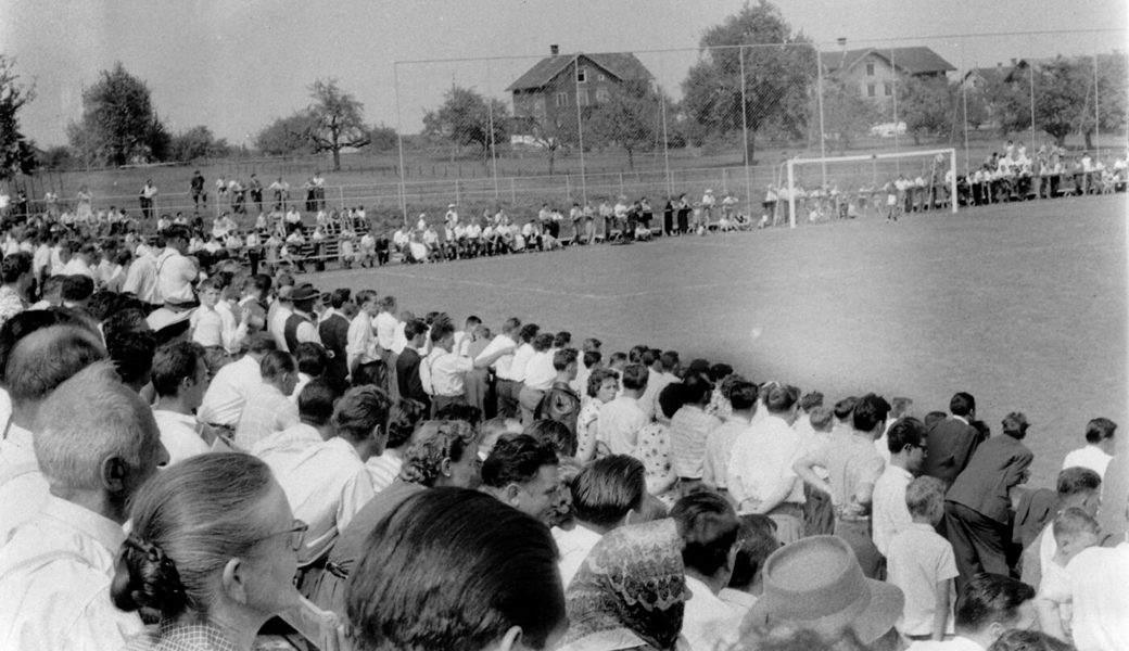  Blick von der errichteten Tribüne auf das von Zuschauern gesäumte Spielfeld.