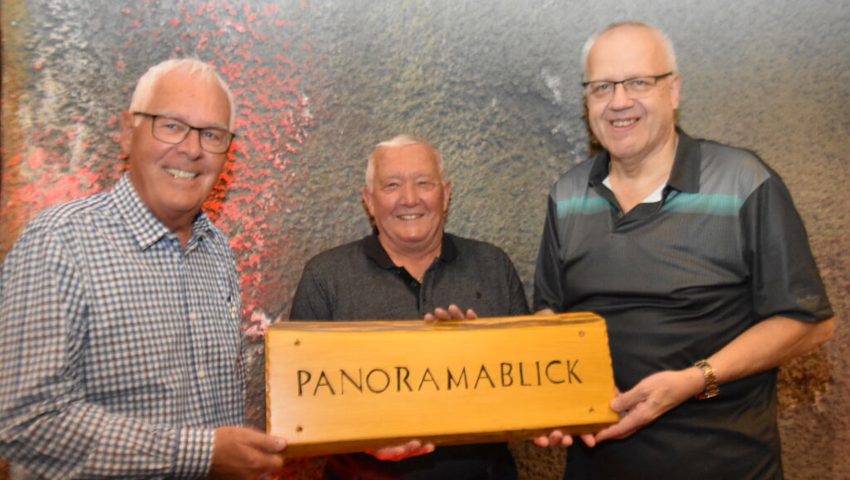  Aus Notunterkunft wird der «Panoramablick»: Hüttenwart Alex Pfiffner, Schnitzer Kurt Willi und «Namensfinder» Jürg Bernasconi (von links) präsentieren mit Stolz das neue Namenschild für das Hüttli bei der Bergstation. 