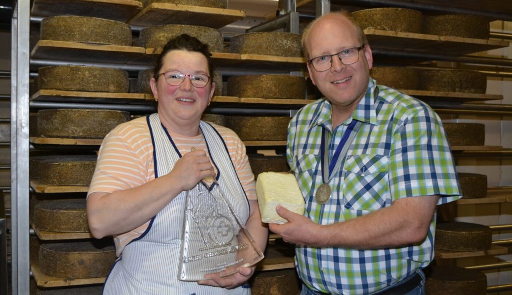  Marianne und Thomas Stadelmann mit der Auszeichnung für den «gereiften Werdenberger Sauerkäse AOP» vor dem Käsegestell mit dem Toggenburger Bio-Blumenkäse, der ein Diplom erhielt. 