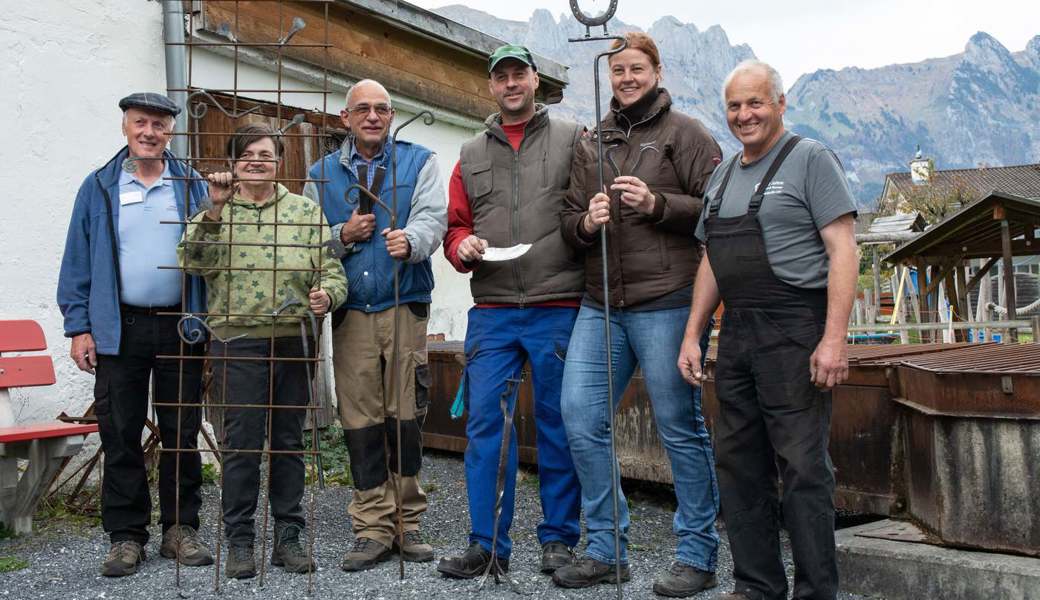 Die Kursteilnehmer, flankiert von den Schmieden Peter Baumgartner (links) und Ruedi Blumer.  