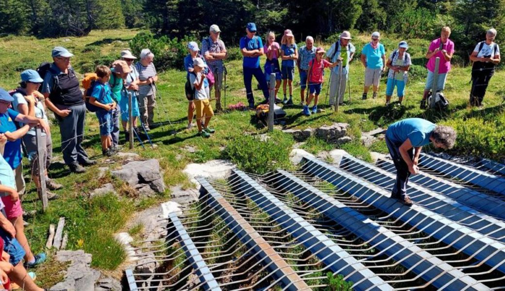  This Isler erläutert den Teilnehmerinnen und Teilnehmern am Wandertag die Löcher in der oberen Neuenalp. Bilder: PD