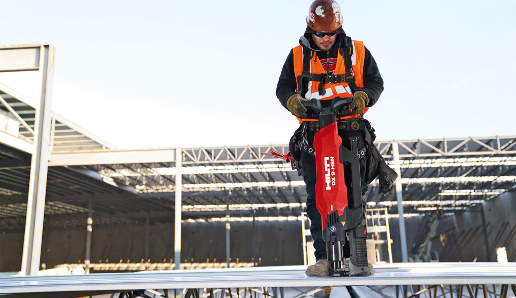 Ein Arbeiter mit einem Hilti-Bolzensetzgerät am Werk.