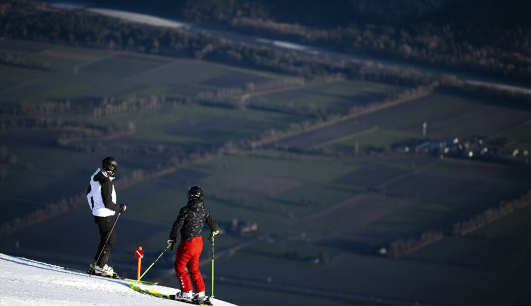  Skifahrer geniessen das milde Wetter im Skigebiet Pizol mit Blick ins grüne Tal. 