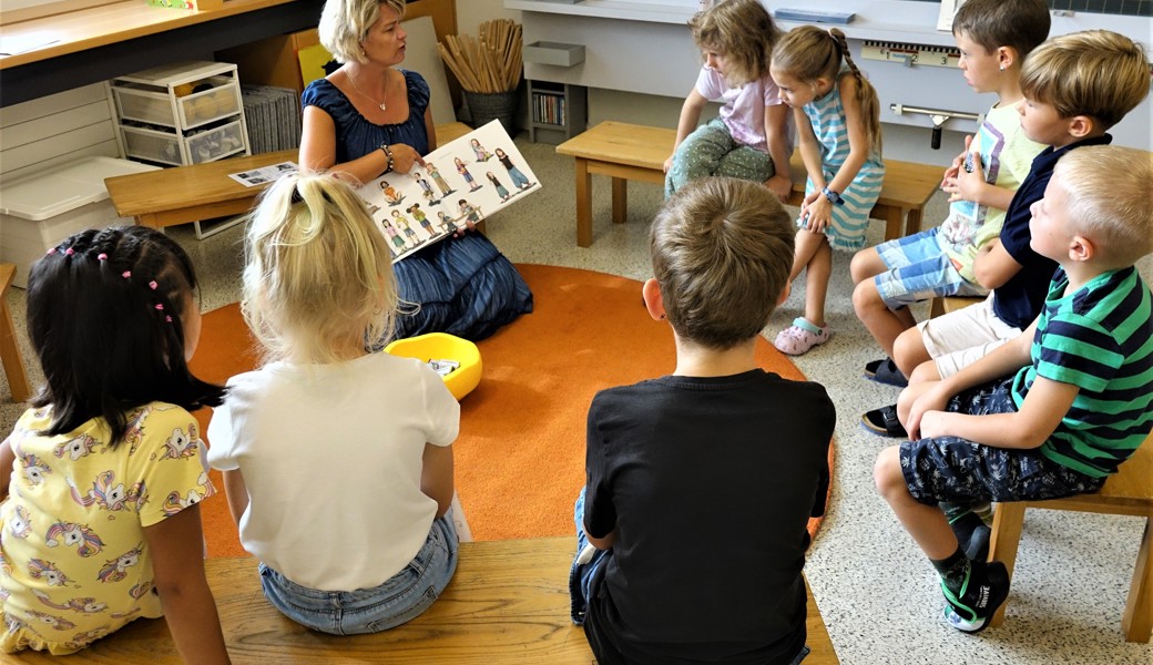 Franca Mäder erzählt den acht Erstklässlern aus dem Buch «Komm mit uns in die Schule».