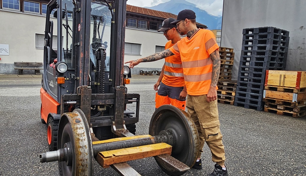 Berufsbildner Armando Walder (rechts) erklärt seinem Lehrling Miguel Caminada den Gabelstapler.