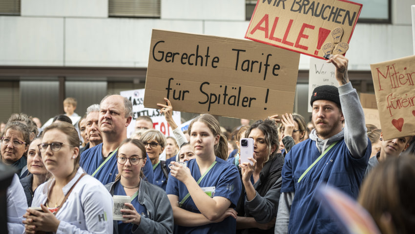 Die Demonstrierenden strecken grosse Kartonschilder in die Luft.