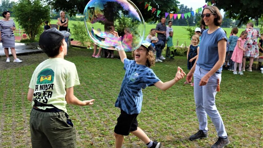  Begeistert kreieren die Buben und Mädchen Seifenblasen.